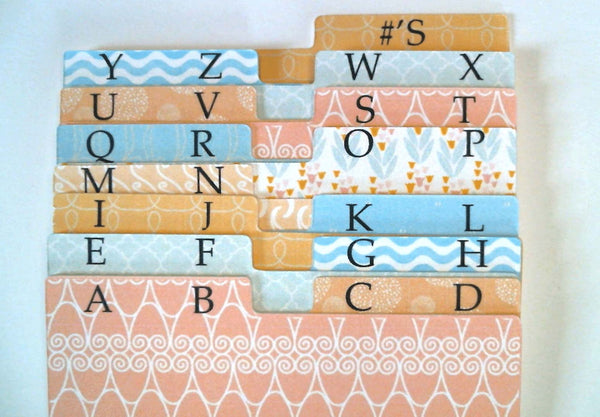 A flat lay of pretty Rolodex dividers in pastel patterns. Each divider has two letters (AB, etc.) per tab printed in black ink.