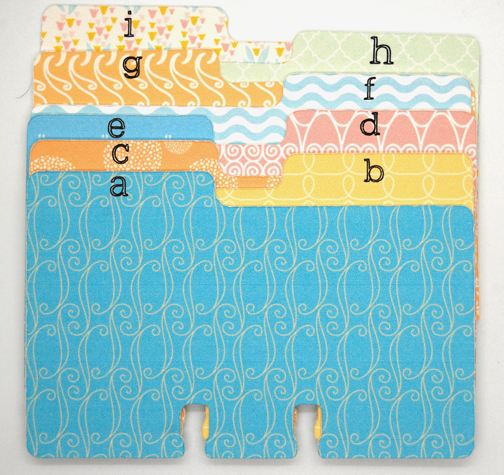 Pretty colored Rolodex dividers in many pastel patterns.  Each divider has a lower case letter from a to i. 