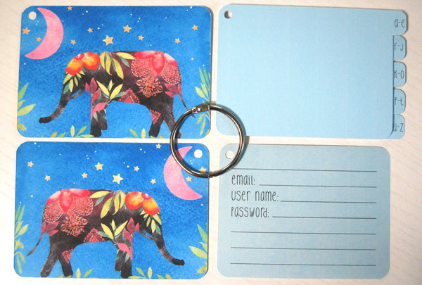Flat lay display of all of the elements of the elephant password keeper: Front and back cover, silver ring, 5 blue dividers, and 40 blue password cards