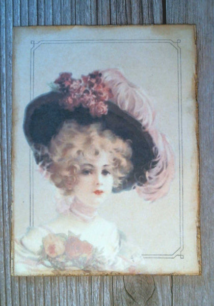 A drawing of a Victorian woman with a large hat made into a post card.