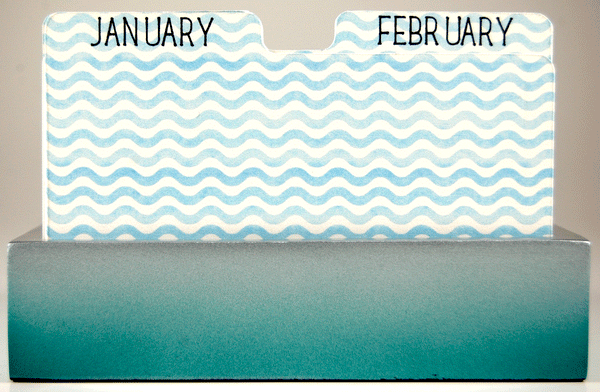 Pretty Rolodex Dividers in a white and blue wavy stripe. The word "JANUARY" is written in black on the first divider and the word "FEBRUARY" is on the second divider. The dividers are in a blue holder.