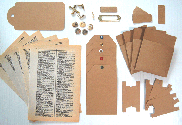 Neutral Ephemera Kit: Kraft cardstock tags, tabs, labels, pockets, old book pages, and buttons, label holder, and gold corners protectors - all arranged on a white table and photographed from above.