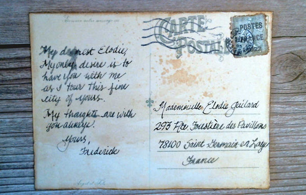 The back of a "vintage" post card with a stamp affixed and handwriting.