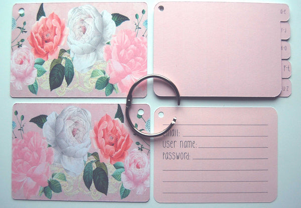 Flat lay display of all of the elements of the pink shabby rose password keeper: Front and back cover, silver ring, 5 pink dividers, and 40 pink password cards