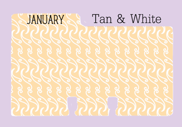 A colored Rolodex divider in a tan and white pattern: The divider is tan with a white swirly print. The word "JANUARY" is written in black on the tab, which is on the left. The divider is on a purple background with the words "Tan and White."