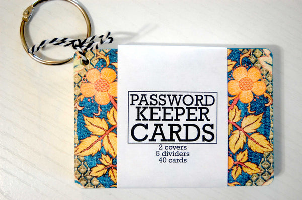 A blue tapestry password keeper - a suitable gift for a seamstress. The password keeper is wrapped  and has a silver ring. The print is a William Morris print with orange and yellow flowers and leaves.