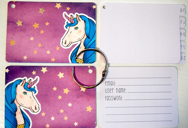 Flat lay display of all of the elements of the unicorn password keeper: Front and back cover, silver ring, 5 purple dividers, and 40 purple password cards